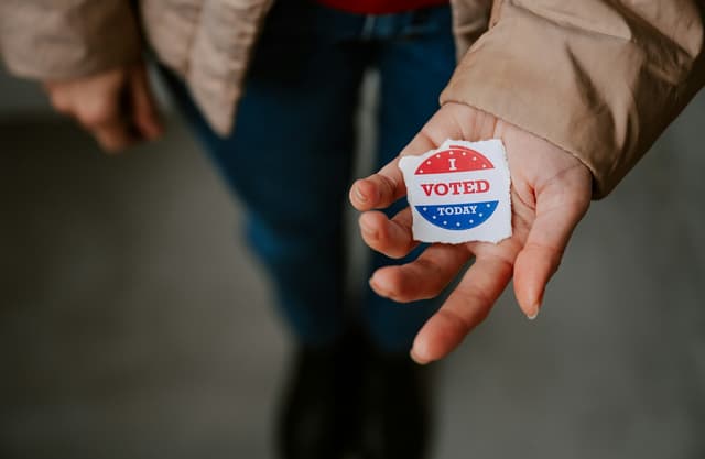 Hand holding i voted sticker. 