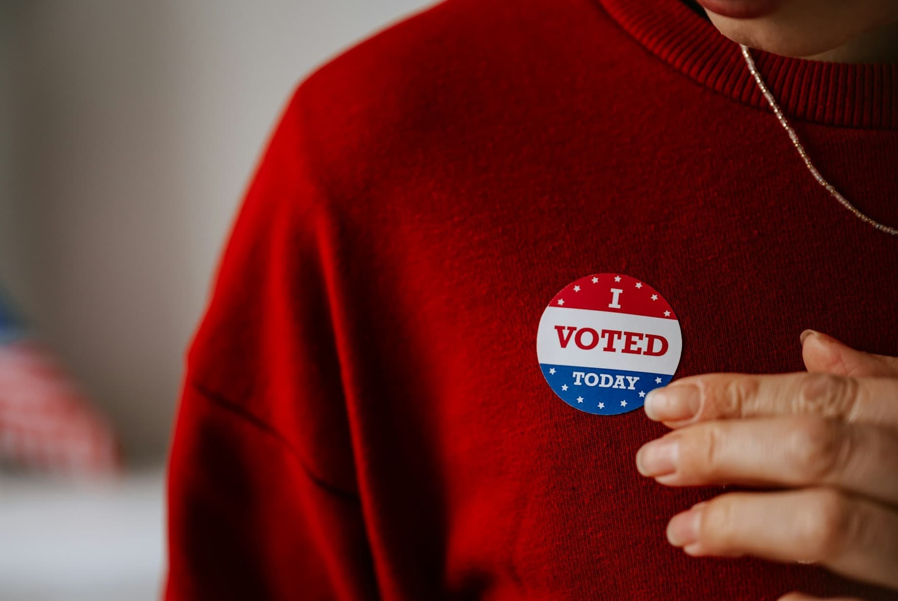 Someone putting on a i voted sticker. 