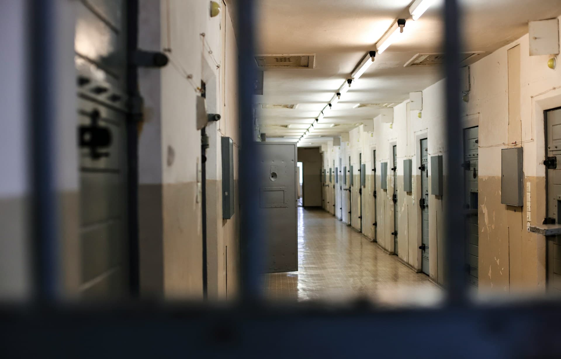 POV shot from behind bars in a jail.