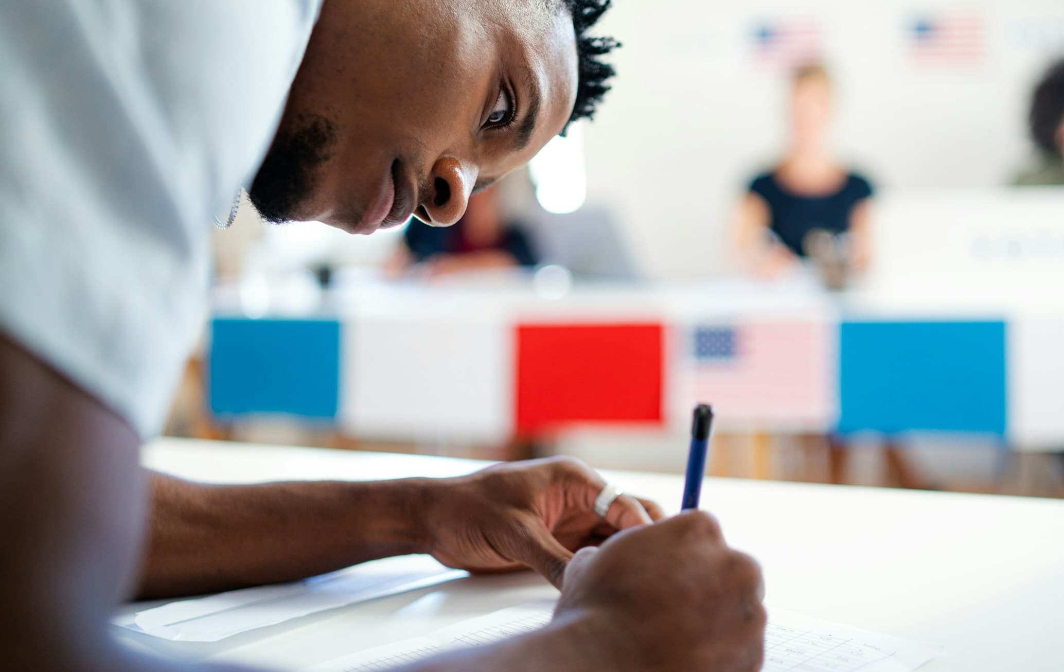 A man filling out his election ballot.