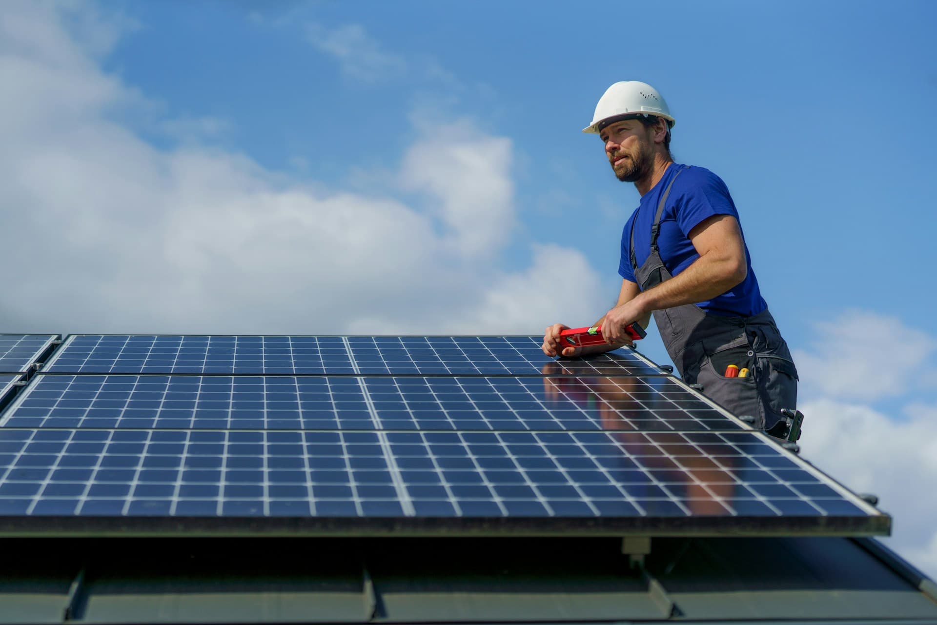 Person installing solar panels on roof. 