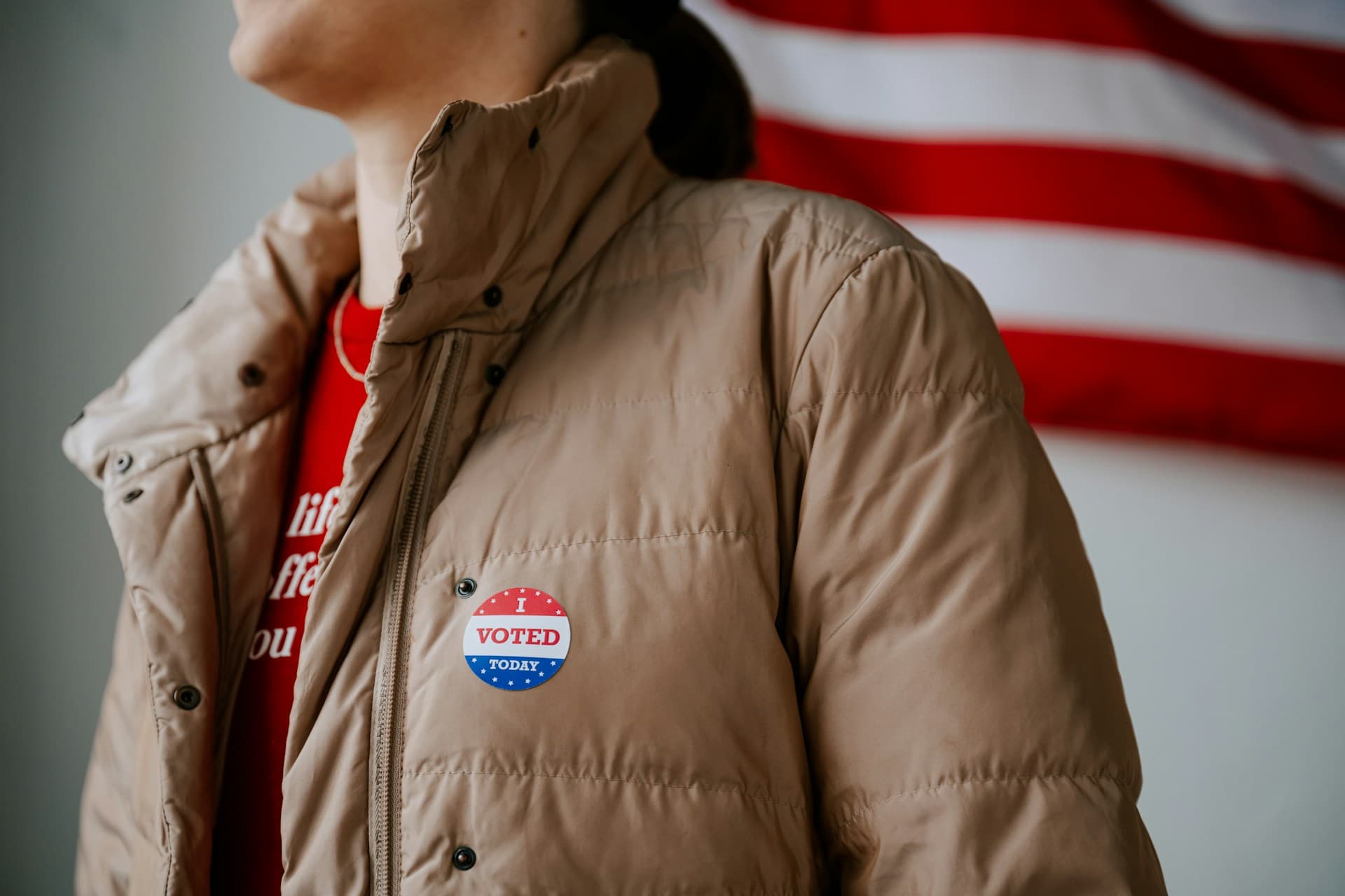 Woman walking away with a I voted sticker on. 