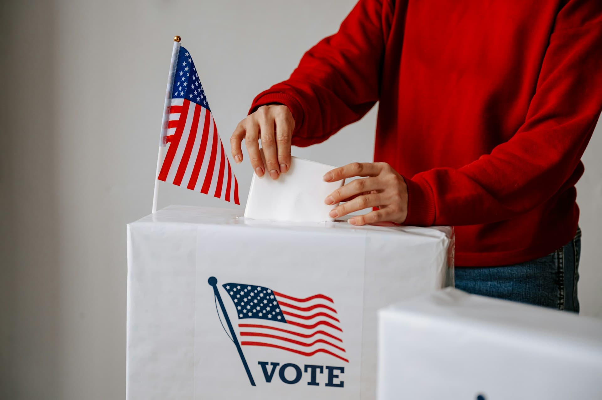 Person placing vote in ballot box. 